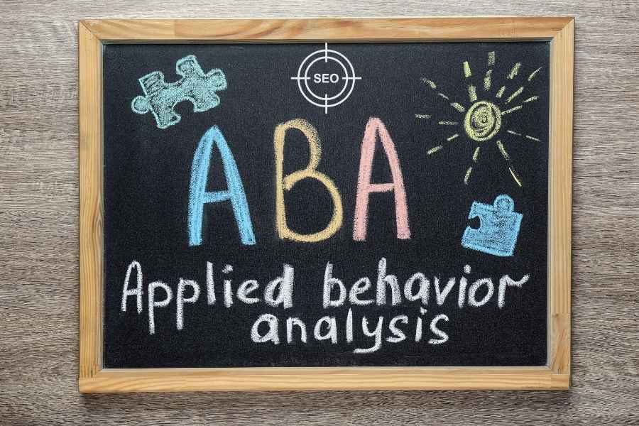 Chalkboard with colorful text reading "ABA Applied Behavior Analysis" and illustrations of puzzle pieces and a sun, symbolizing autism support and therapy